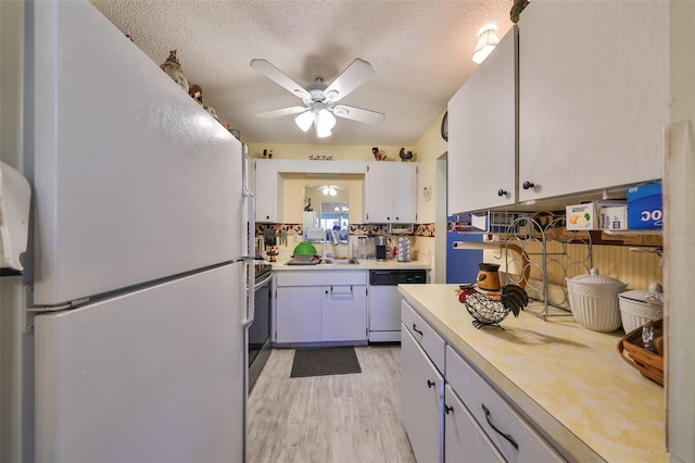 kitchen featuring ceiling fan, dishwasher, white fridge, electric stove, and white cabinets