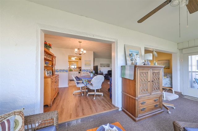 interior space featuring wood-type flooring and ceiling fan with notable chandelier