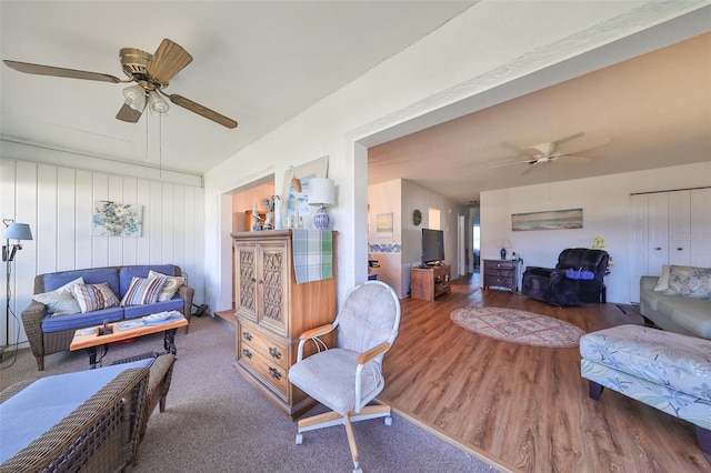 living room featuring ceiling fan and dark wood-type flooring