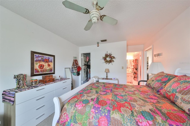 carpeted bedroom with ceiling fan, a textured ceiling, and ensuite bath