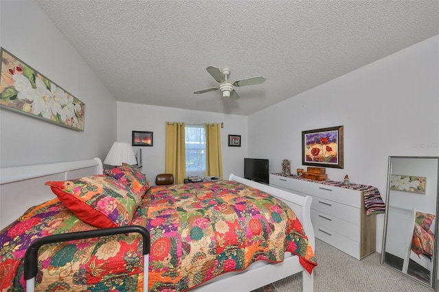 bedroom with a textured ceiling, ceiling fan, and light carpet