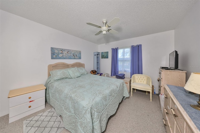 carpeted bedroom with ceiling fan and a textured ceiling