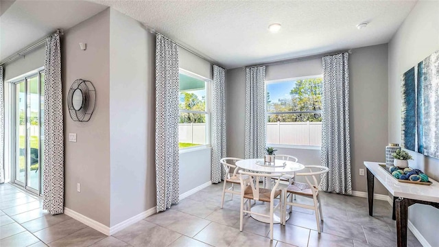 tiled dining space with a textured ceiling