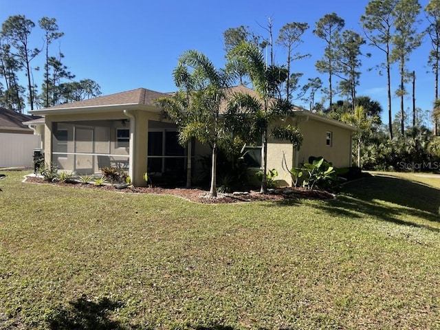 back of house with a sunroom and a yard