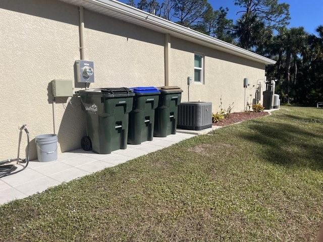 view of home's exterior with a lawn and central AC unit