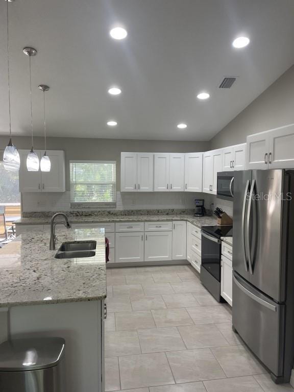 kitchen with sink, white cabinets, lofted ceiling, and appliances with stainless steel finishes