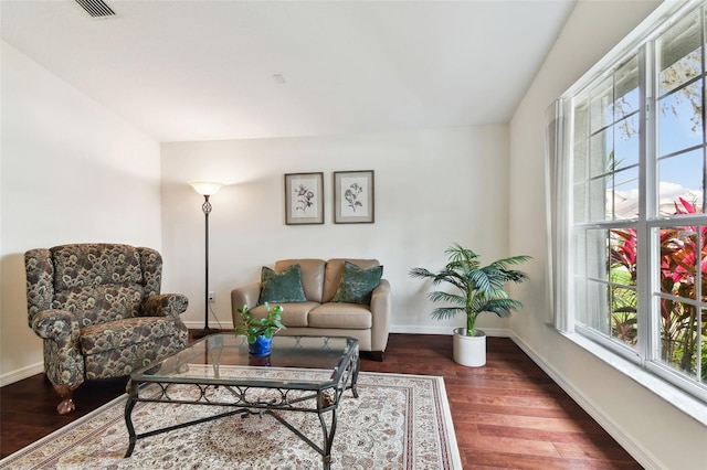 living room featuring dark wood-type flooring and plenty of natural light