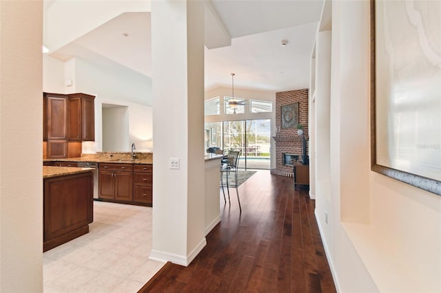 hall with high vaulted ceiling, light hardwood / wood-style floors, and sink