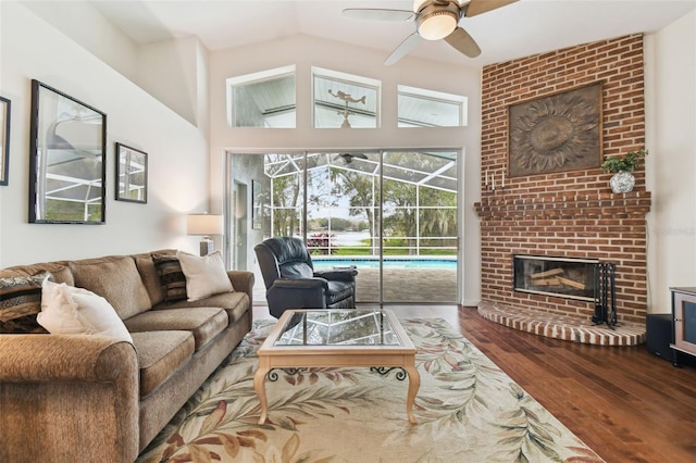 living room with ceiling fan, lofted ceiling, hardwood / wood-style floors, and a fireplace