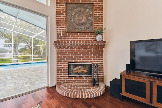 living room with a fireplace and dark wood-type flooring