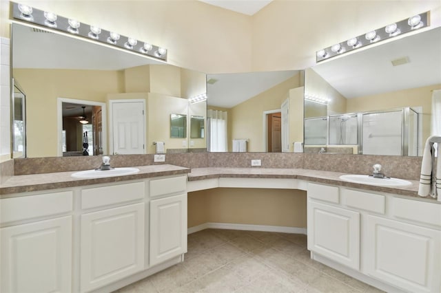 bathroom with vaulted ceiling, vanity, tile patterned floors, and a shower with shower door