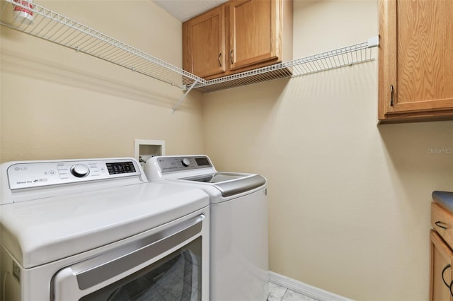 washroom featuring cabinets and washer and clothes dryer