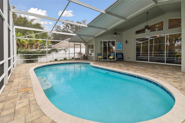 view of pool with ceiling fan, glass enclosure, and a patio