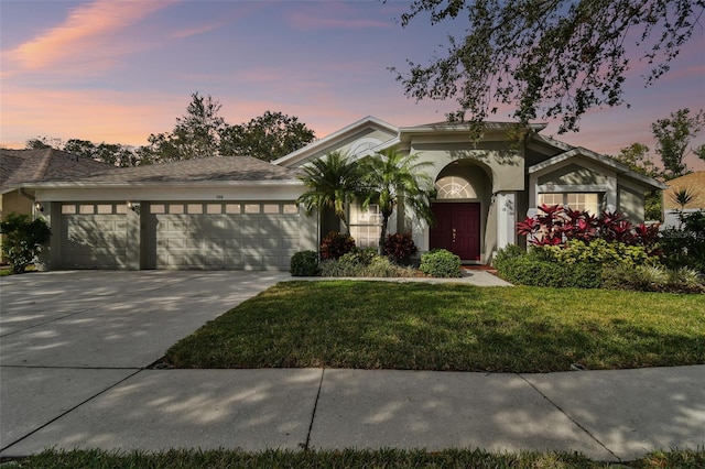 view of front of house with a garage and a lawn