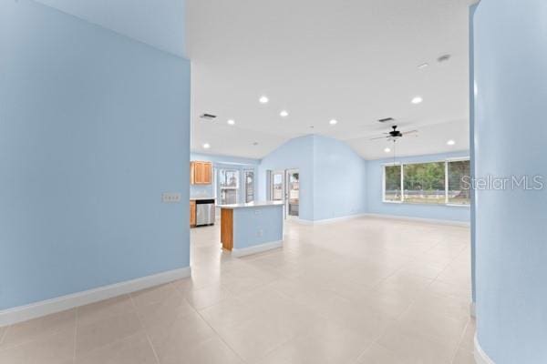 unfurnished living room with ceiling fan, light tile patterned flooring, and lofted ceiling