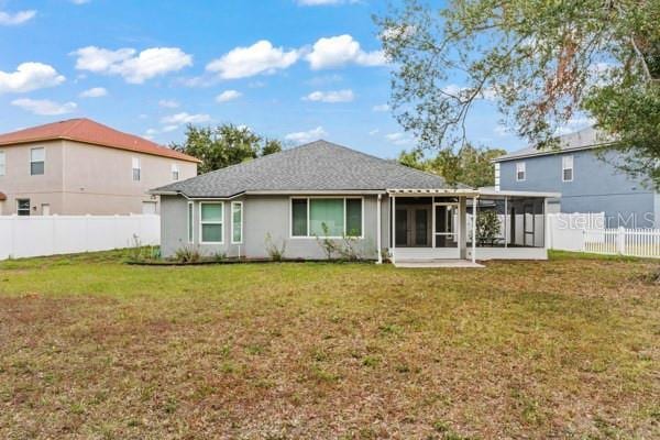 rear view of house with a sunroom and a yard