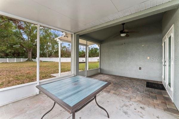 unfurnished sunroom featuring ceiling fan