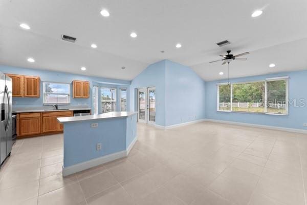 kitchen featuring a wealth of natural light, a kitchen island, vaulted ceiling, and ceiling fan