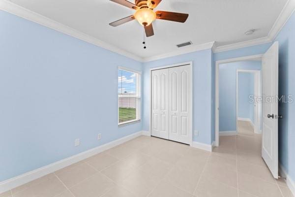 unfurnished bedroom featuring ceiling fan, a closet, light tile patterned floors, and ornamental molding