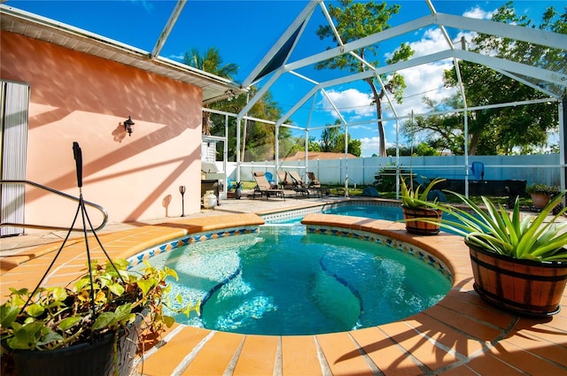 view of swimming pool with a patio, a lanai, and an in ground hot tub