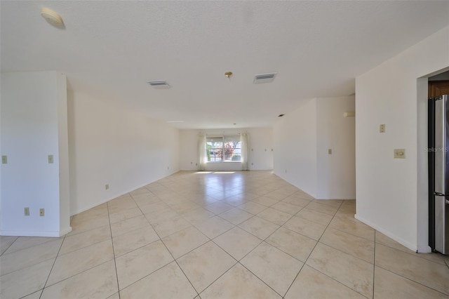 tiled empty room with an inviting chandelier