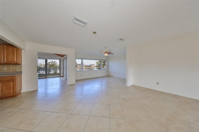 unfurnished living room featuring light tile patterned floors and ceiling fan