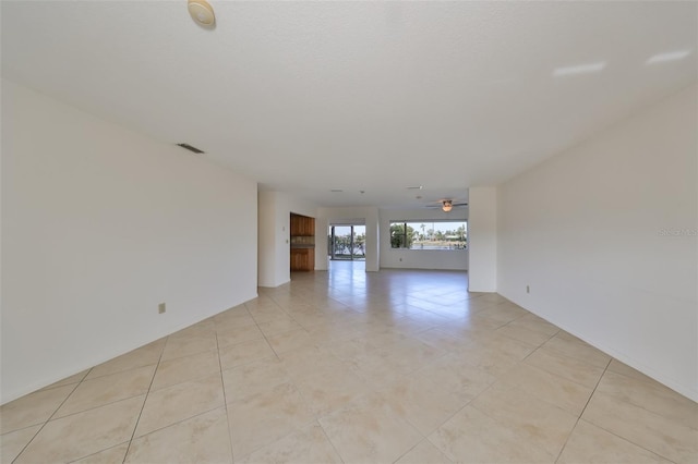 unfurnished room with ceiling fan and light tile patterned flooring