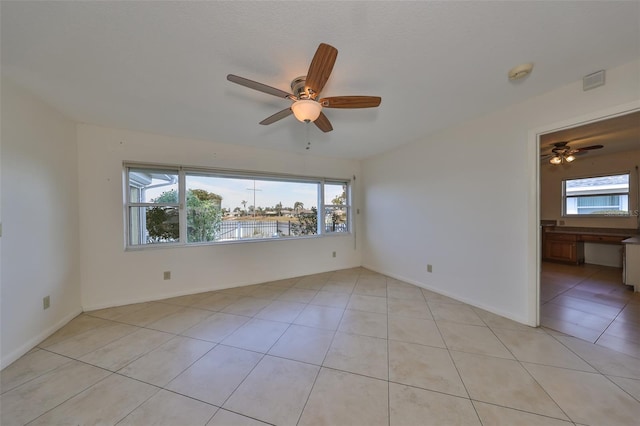 tiled empty room with ceiling fan