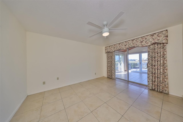 unfurnished room featuring ceiling fan, light tile patterned floors, and a textured ceiling