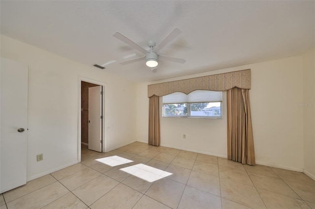 empty room with ceiling fan and light tile patterned flooring