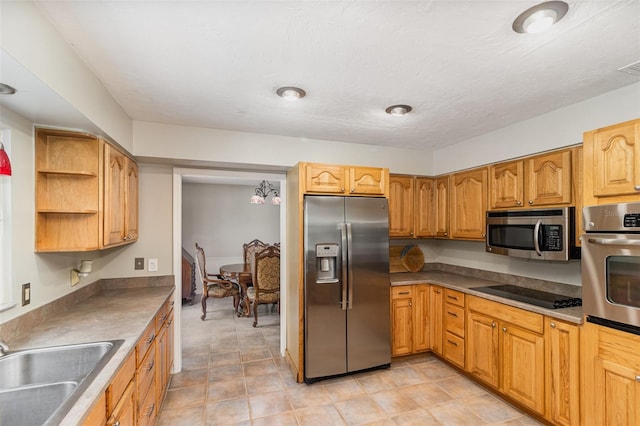 kitchen featuring a textured ceiling, sink, light tile patterned floors, and stainless steel appliances