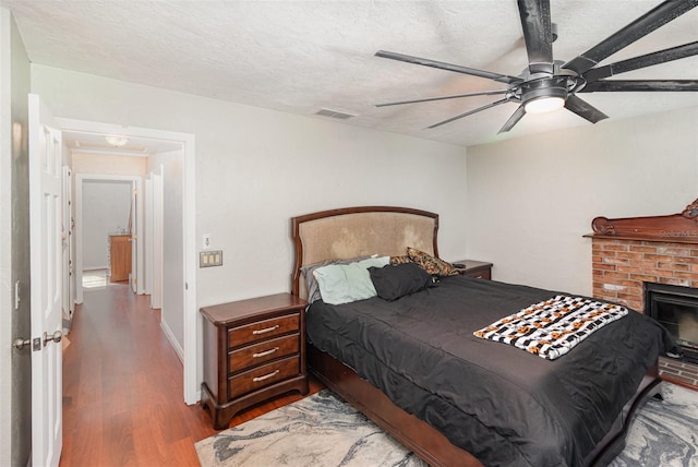 bedroom featuring ceiling fan, wood-type flooring, and a textured ceiling