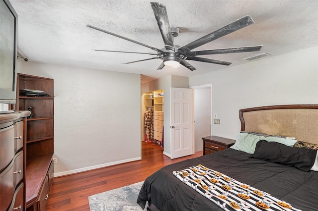 bedroom featuring a textured ceiling, dark hardwood / wood-style floors, and ceiling fan