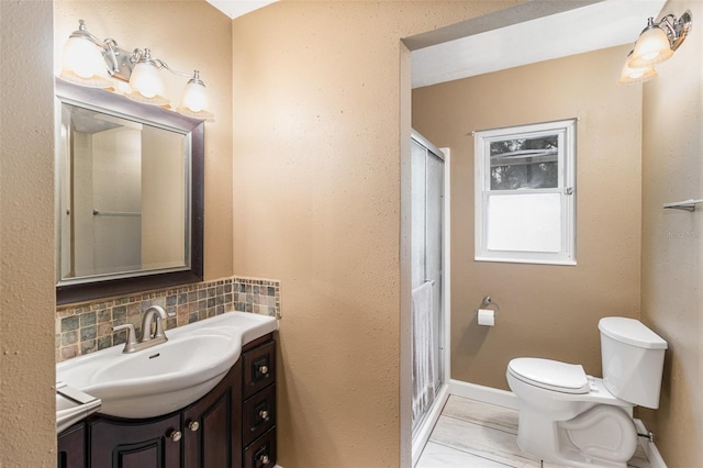 bathroom with decorative backsplash, vanity, toilet, and a shower with door