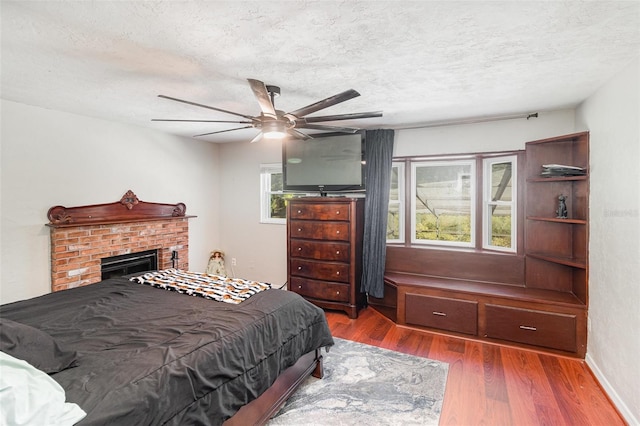 bedroom with a textured ceiling, dark hardwood / wood-style floors, and ceiling fan