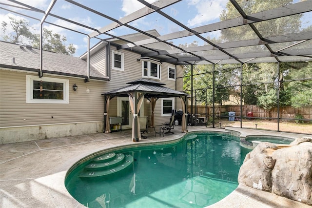 view of pool with a gazebo, glass enclosure, a patio area, and an in ground hot tub