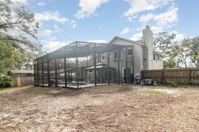 rear view of property featuring glass enclosure