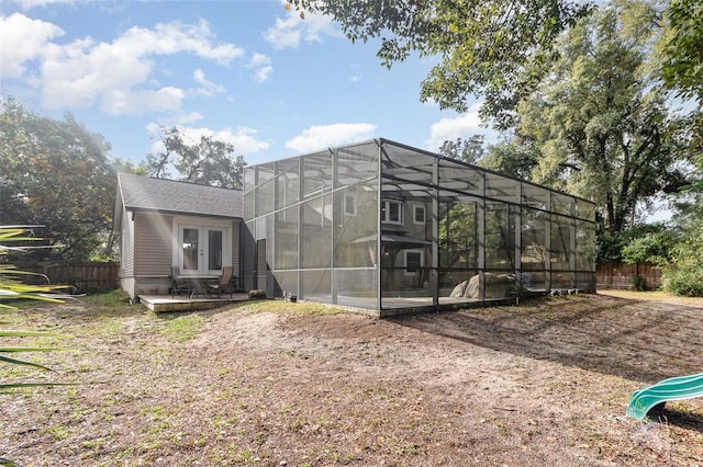 rear view of house featuring french doors and glass enclosure