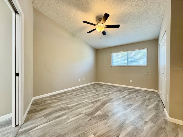 unfurnished bedroom with ceiling fan and a textured ceiling