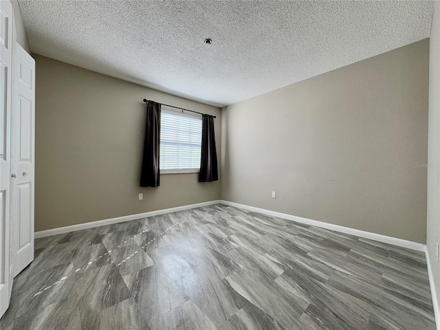 spare room with hardwood / wood-style flooring and a textured ceiling