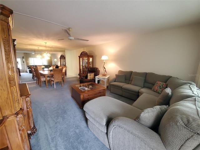 living room with carpet and ceiling fan with notable chandelier