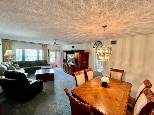 dining area with ceiling fan with notable chandelier, visible vents, carpet floors, and a textured ceiling