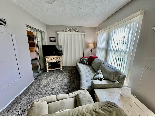 living room featuring visible vents, carpet floors, and a textured ceiling