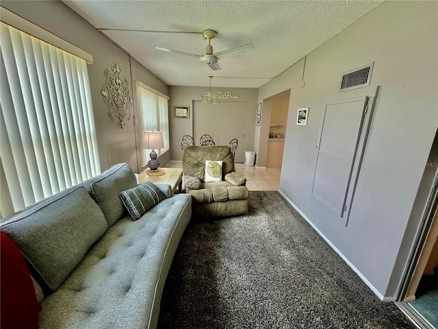 interior space featuring a ceiling fan, baseboards, visible vents, carpet floors, and a textured ceiling