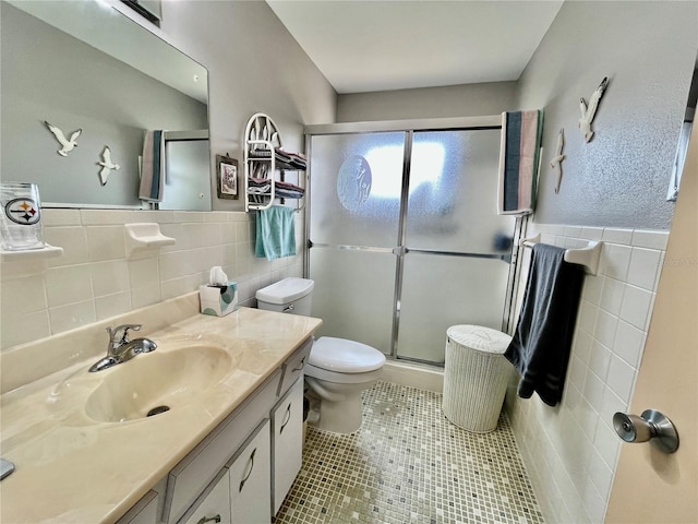 full bathroom with tile patterned flooring, toilet, a stall shower, and tile walls