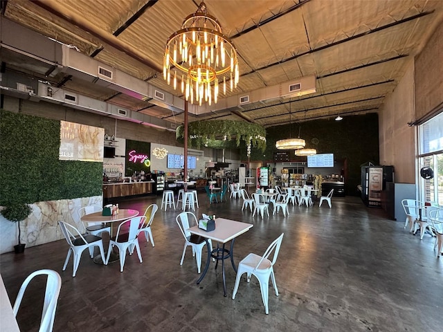 dining room featuring a towering ceiling and an inviting chandelier