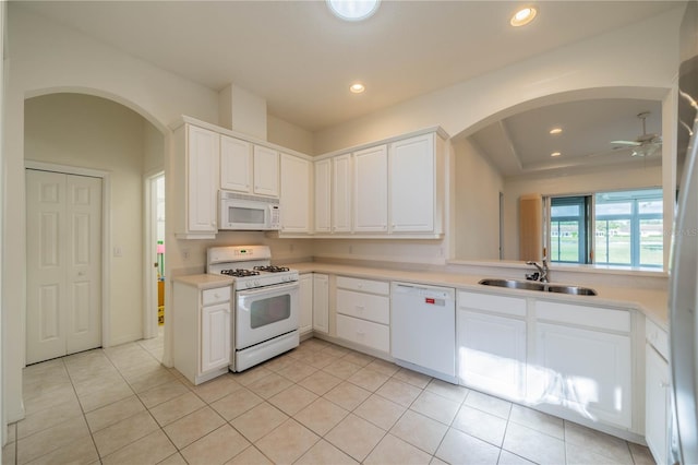 kitchen with sink, white appliances, light tile patterned floors, and white cabinets