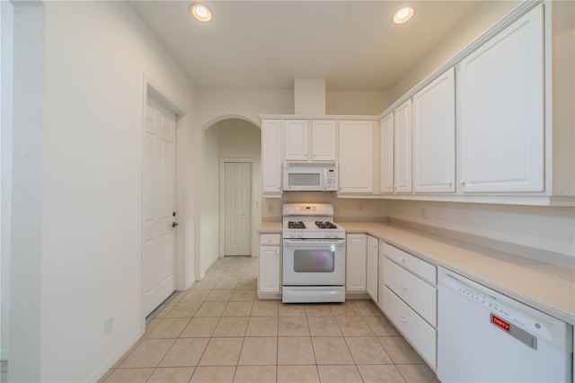 kitchen featuring white cabinetry, light tile patterned floors, and white appliances