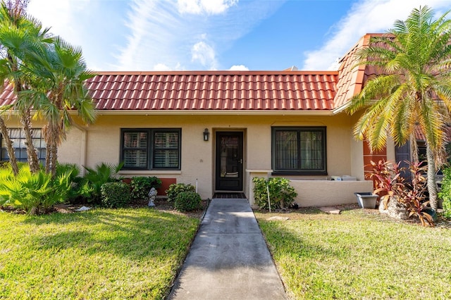 19029 US Highway 19 Unit 25D, Clearwater, FL 33764 - view of front of property with a front yard, stucco siding, and a tiled roof
