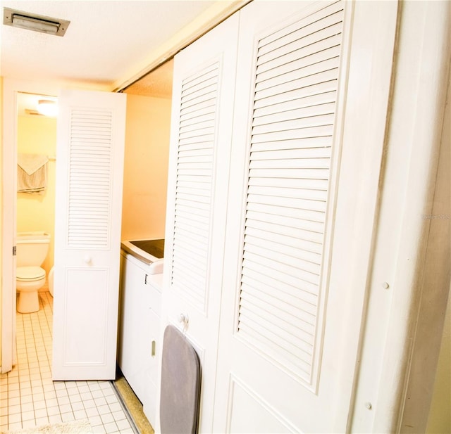 laundry area with light tile patterned flooring